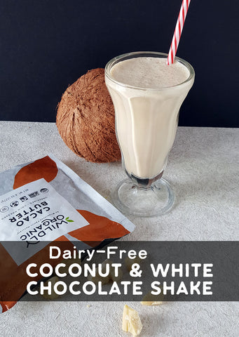 Dairy-free coconut and white chocolate shake with a straw, next to a coconut and packaging.