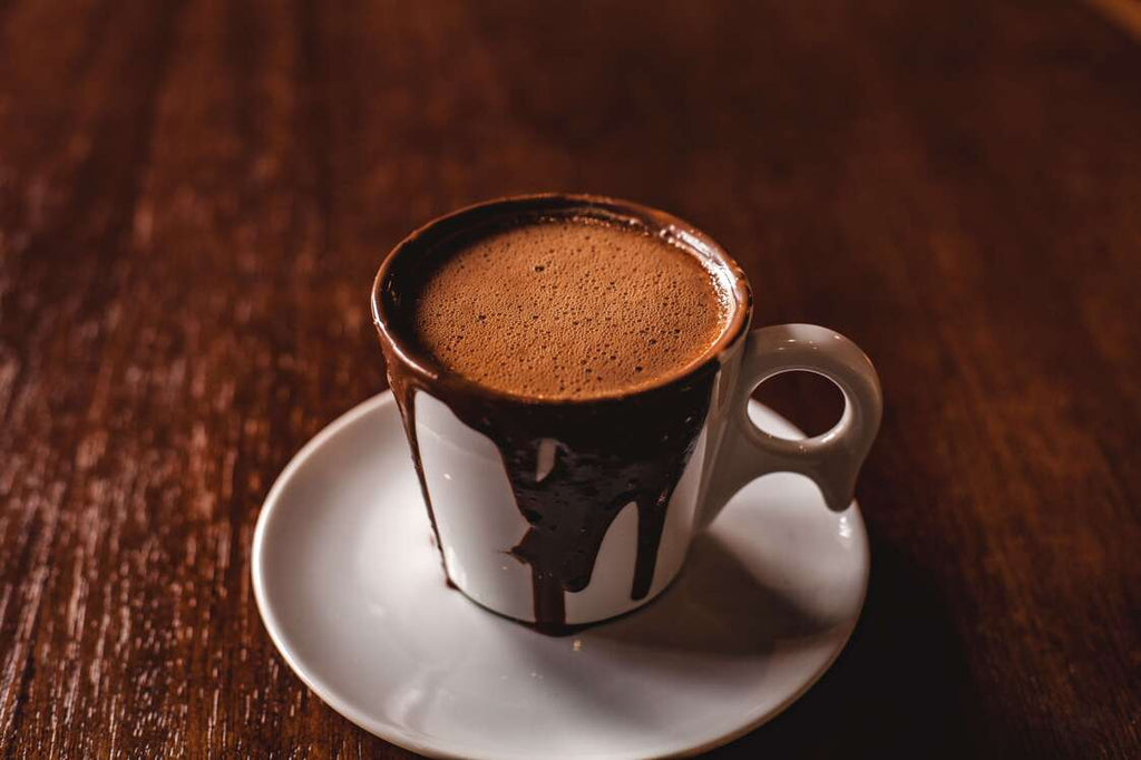 A white saucer and mug containing hot chocolate