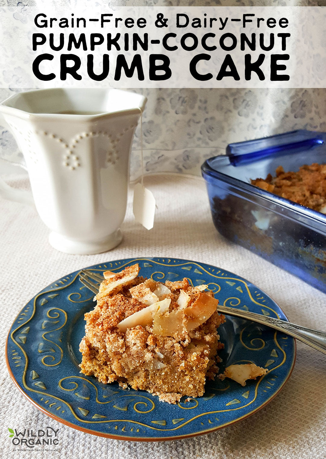 A slice of grain-free, dairy-free pumpkin-coconut crumb cake on a blue plate with a fork, next to a white mug and a baking dish