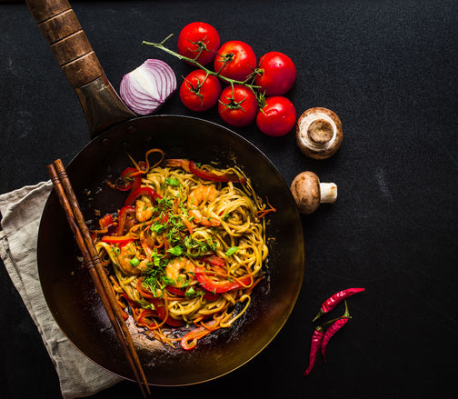 Stir fry wok with chopsticks and vegetables