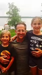 Dr. John Pepelnjak and family smiling near a waterfront